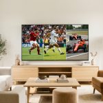 Salon lumineux et moderne avec un téléviseur connecté montrant simultanément du football, du rugby et une course automobile.